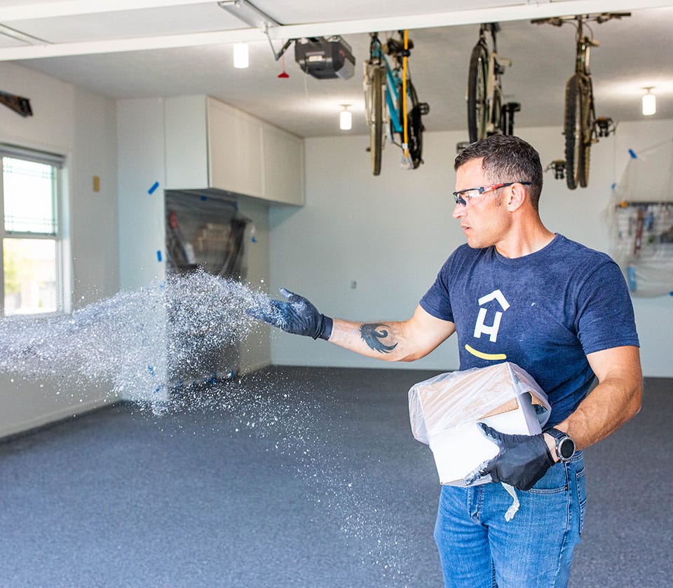 Hello Garage technician applying specks to garage floor