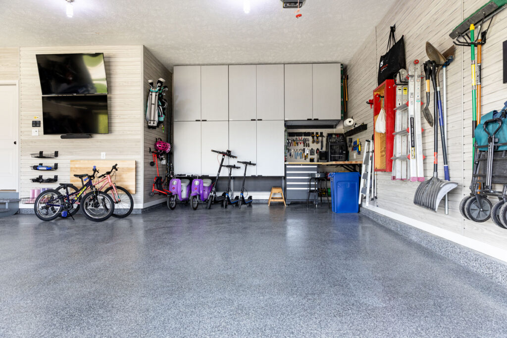 Renovated garage with slatwall, cabinets and tvs on the wall
