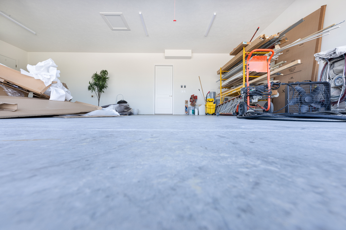 Garage with uncoated concrete and clutter