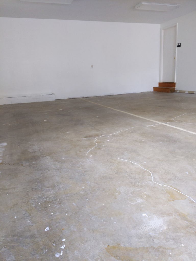 Bare Concrete Floor with cracks in a garage