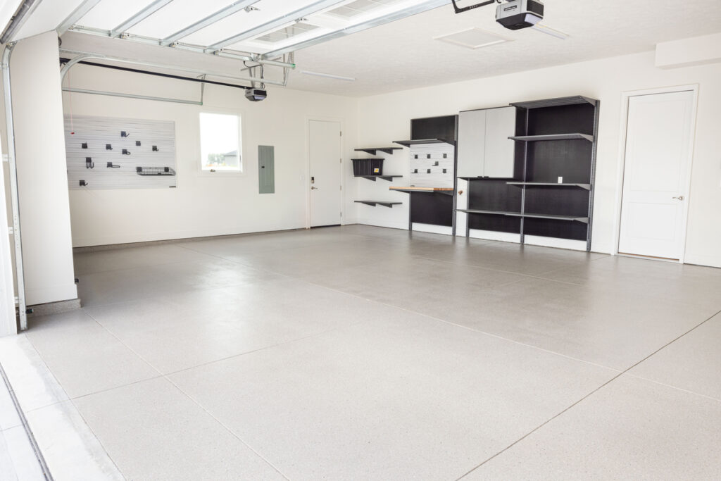 Garage with gray flooring, cabinets and slatwall