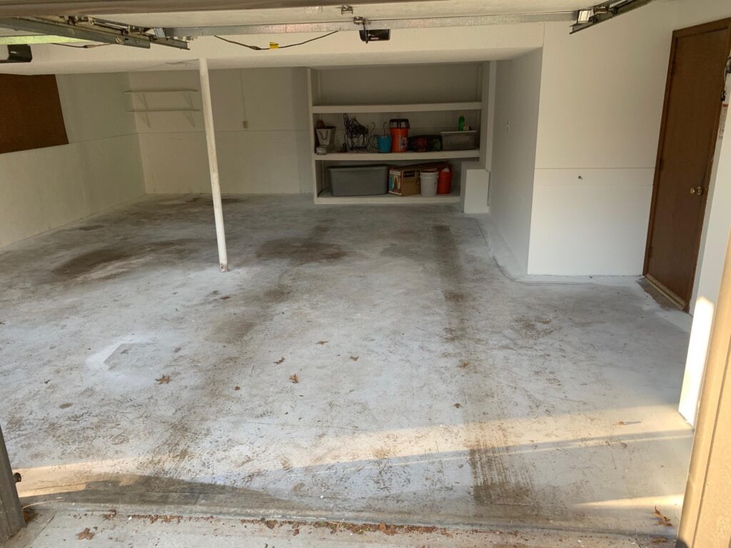 Stained bare concrete garage floor