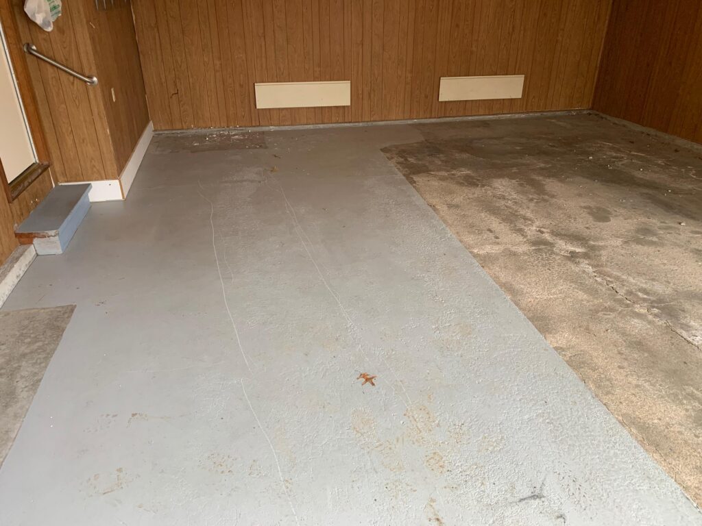 Painted Garage Floor with paneled walls before a garage makeover