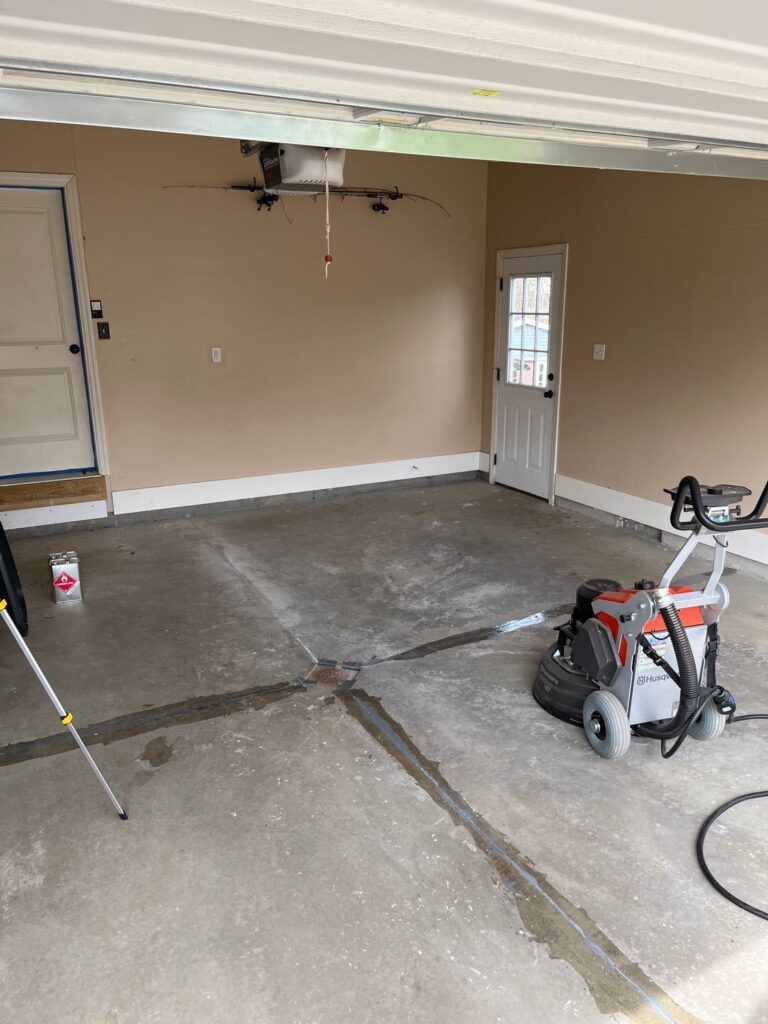Concrete in garage with an industrial grinder on the ground