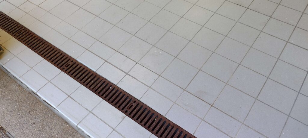 Old titled garage floor with a garage drain in it