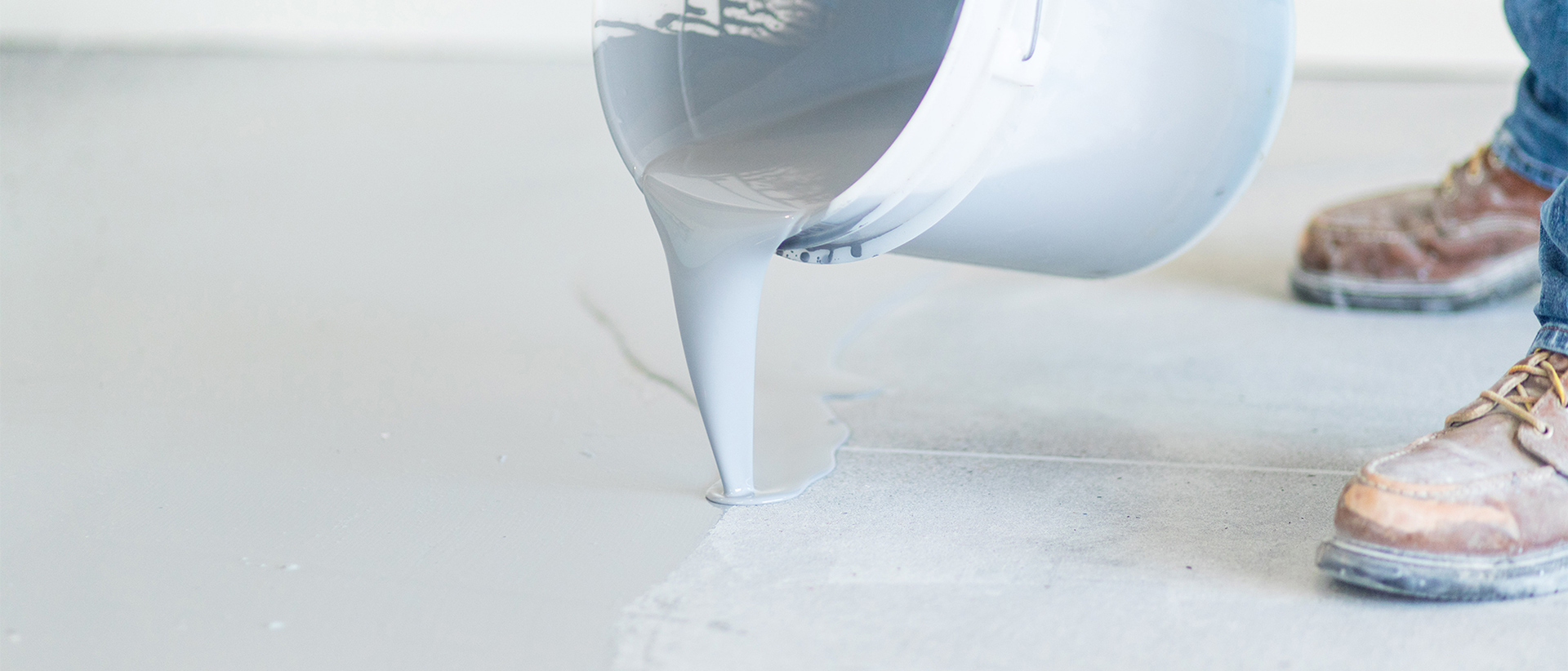 ServiceDetail_GarageFloor_Hero Man pouring coating on garage floor