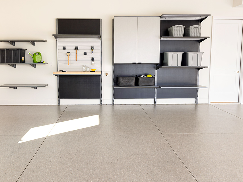 ServiceDetail_GarageFloor_LifestyleImage_Granite Garage with shelving and a workbench featuring granite concrete flooring