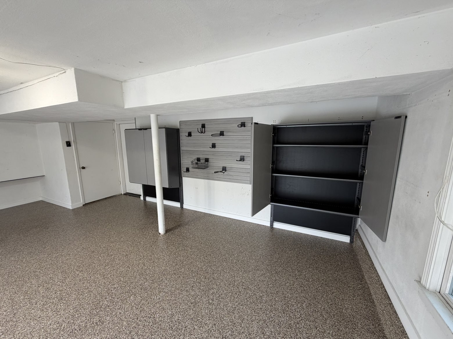 Garage with flooring and custom storage and slatwall