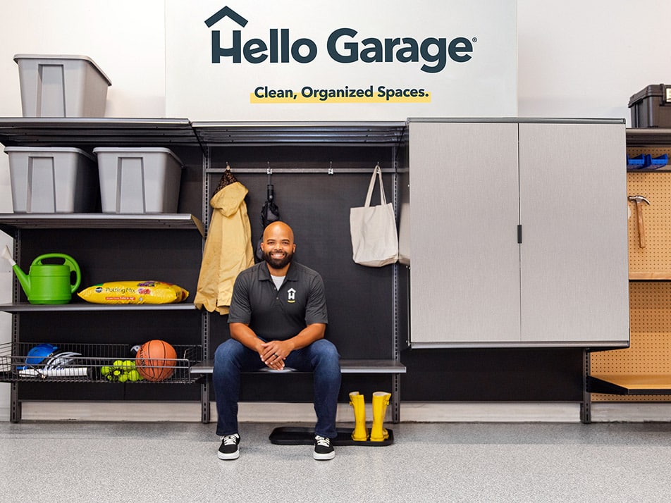 Hello Garage technician sitting on bench smiling