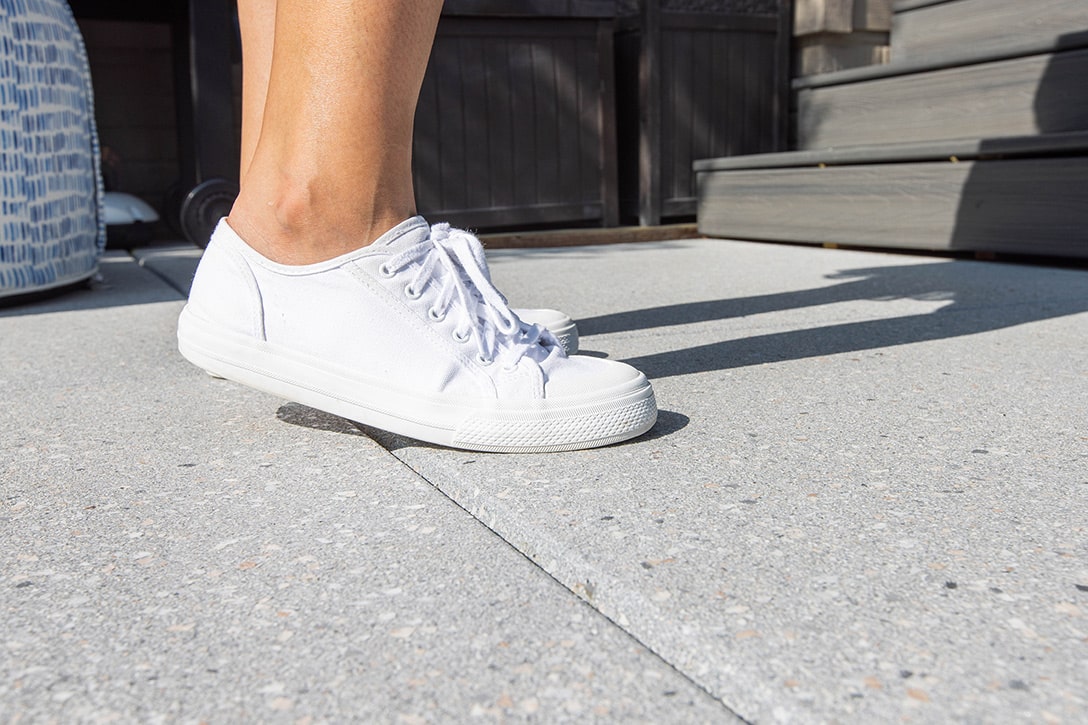 Person standing outside in white tennis shoes