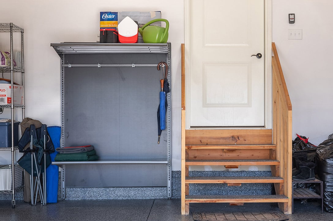 Inside garage door with medal hooks and bench