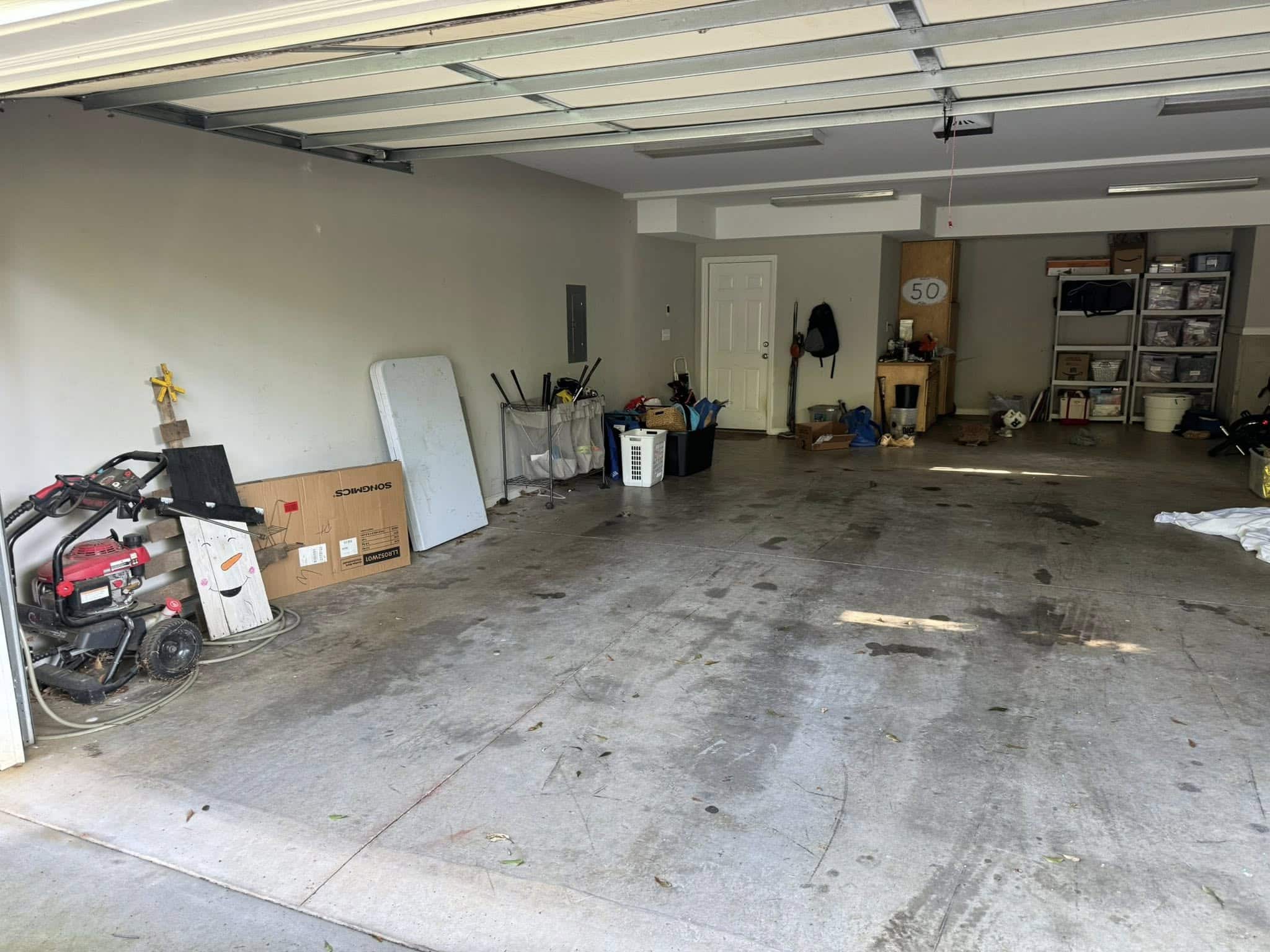 Cluttered garage with bare concrete floor