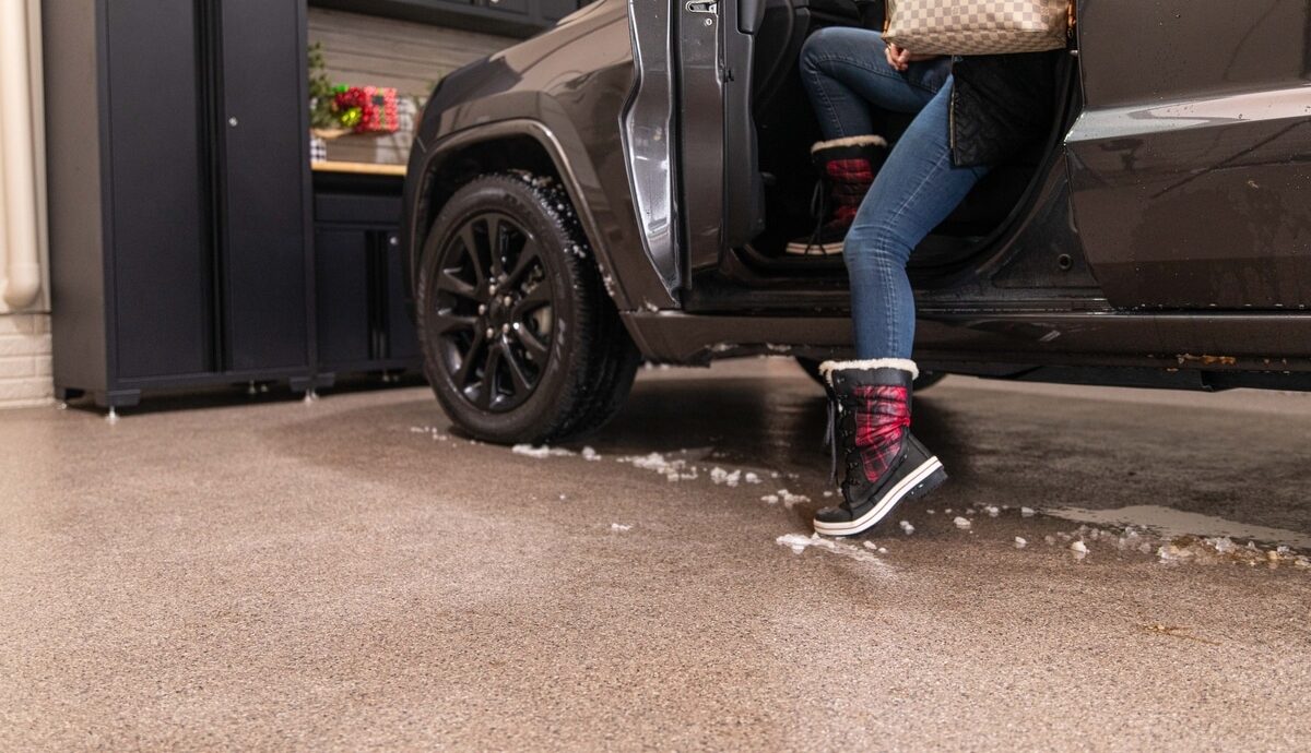Person getting out of car in a garage with snow boots