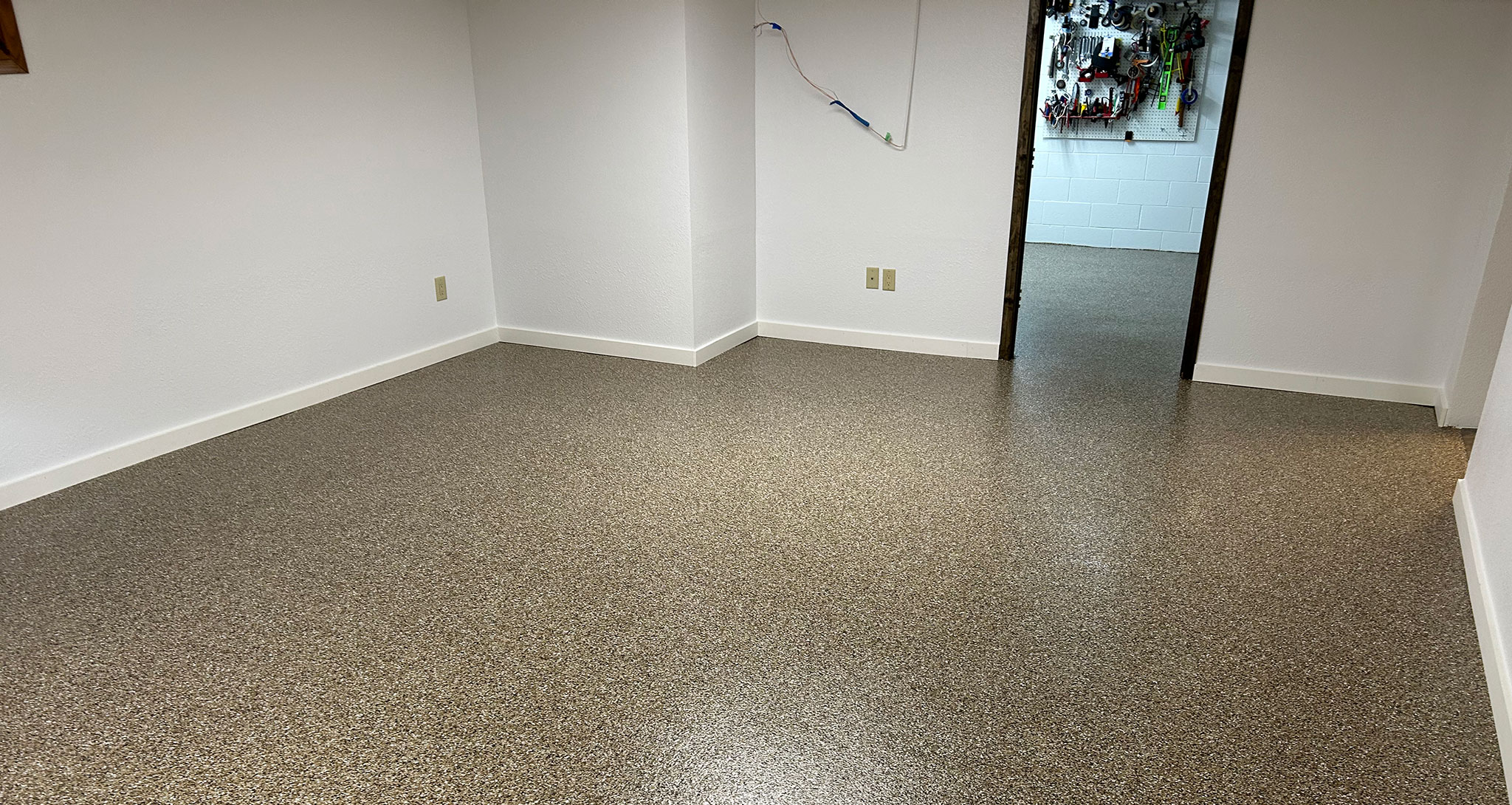 Garage with white baseboards against a brown floor