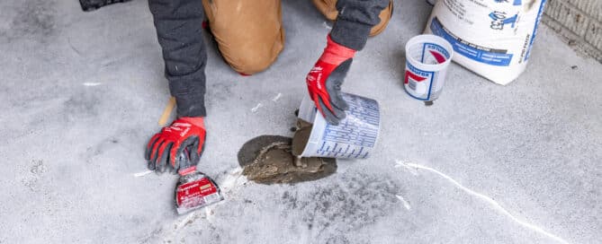 Man fixing garage cracks on floor