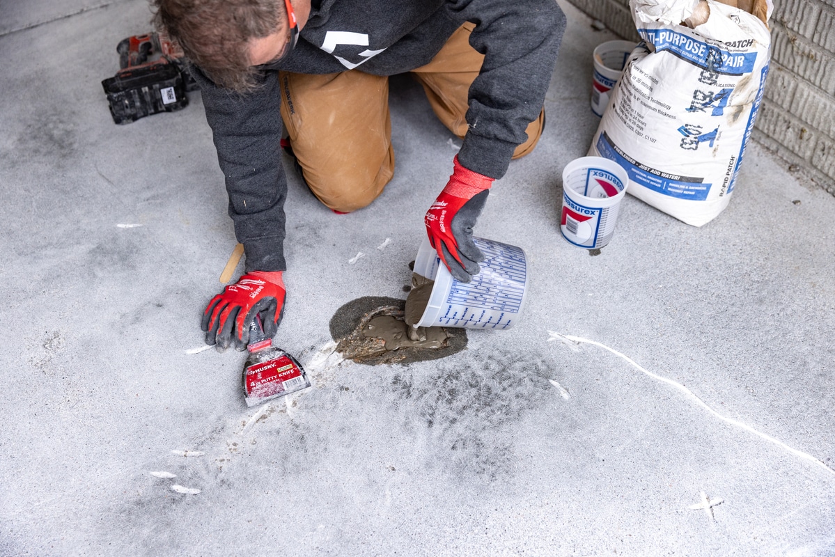 Man fixing garage cracks on floor