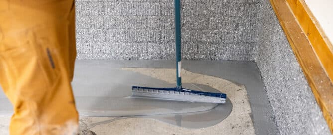 Man laying polyaspartic on garage concrete floor