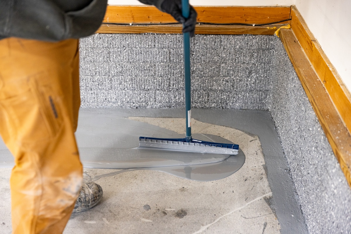 Man laying polyaspartic on garage concrete floor