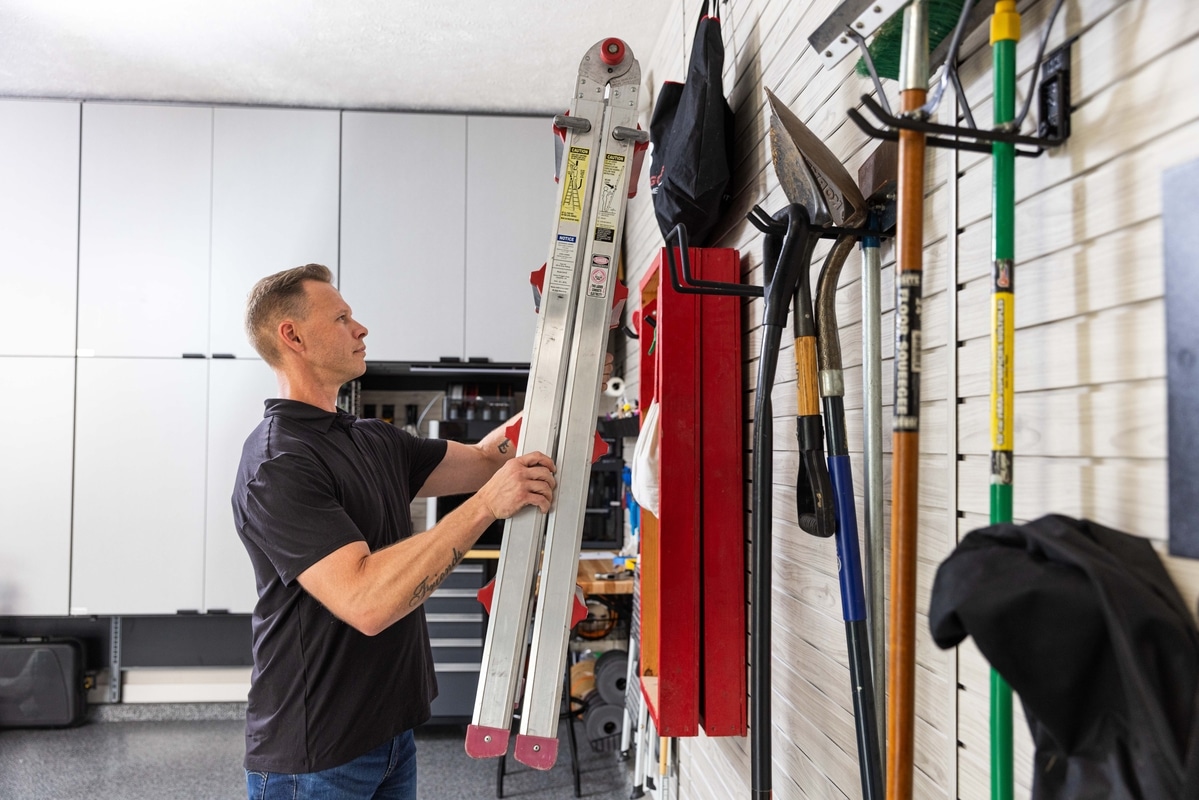 man hanging ladder on wall